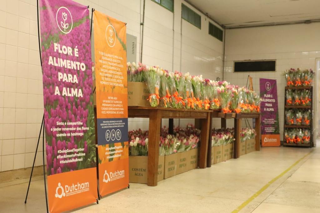 Foto de uma bancada com caixas de tulipas que foram entregues para os profissionais da saúde da rede municipal.